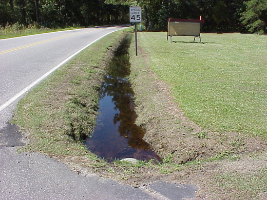 water-filled drainage ditch along road
